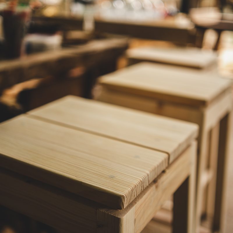 Background image of furniture woodworking workshop, carpenters industrial wooden material work table with different craft tools and wood cutting stand, vintage filter image